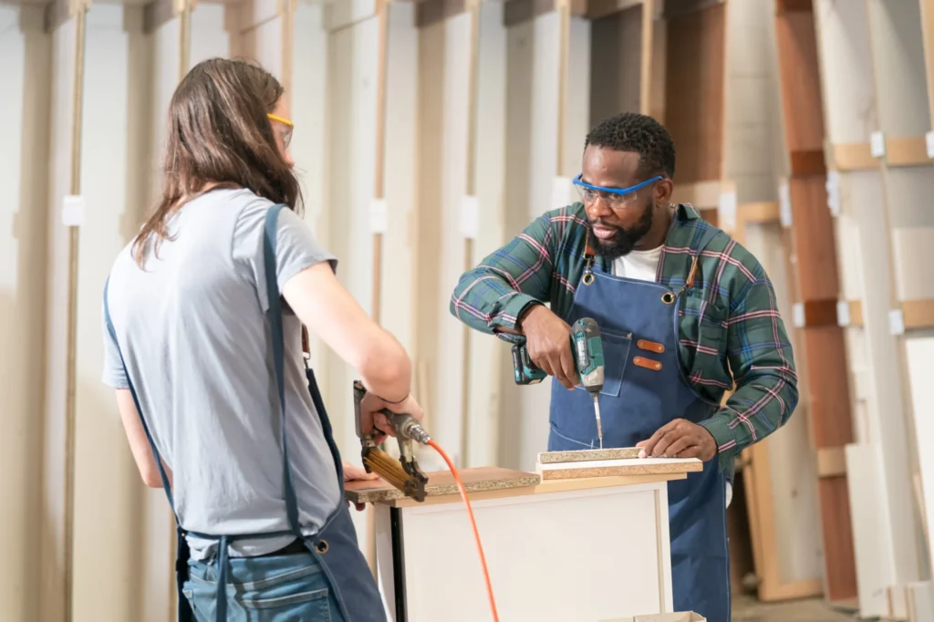 Two craftsmen assembling custom kitchen cabinets in a woodworking shop