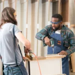 Two craftsmen assembling custom kitchen cabinets in a woodworking shop
