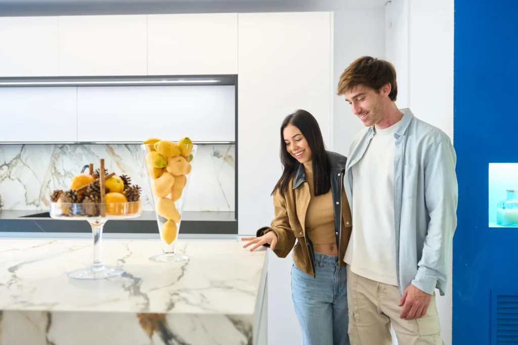 couple examining a marble kitchen island surface in a modern showroom