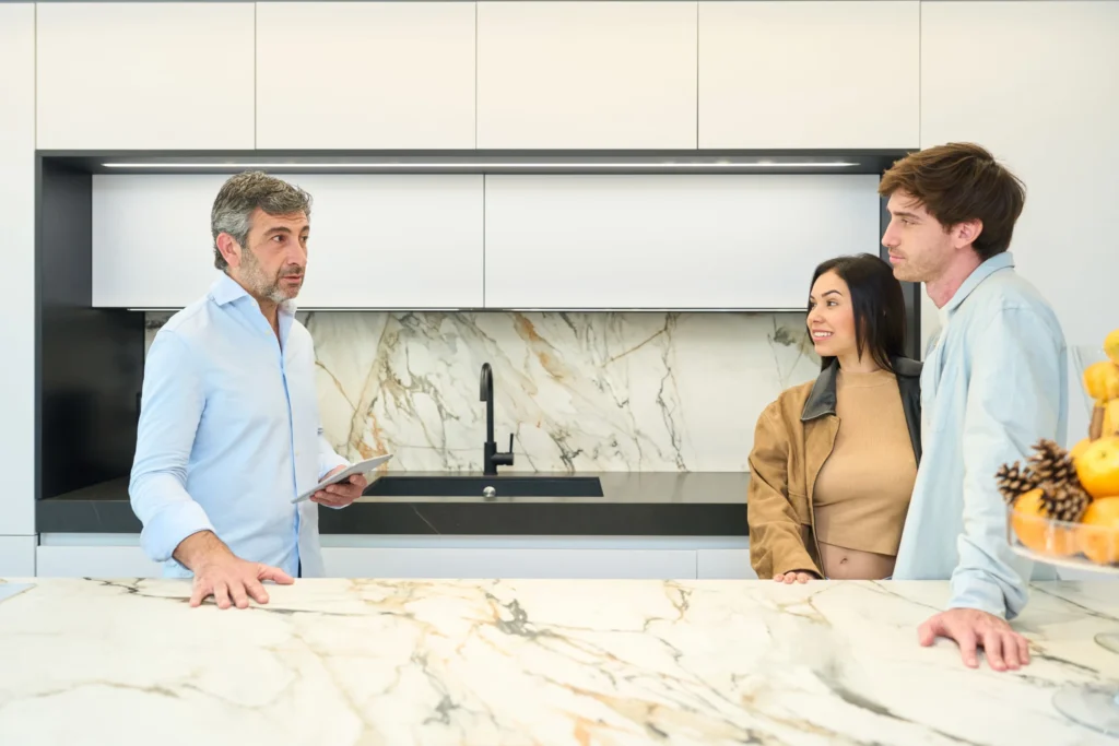 Couple consulting with interior designer about selecting a marble kitchen countertop.