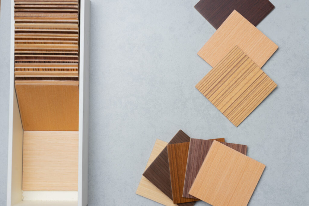 Selection of warm wood veneer samples in light, medium, and dark earthy tones for modern cabinet finishes.