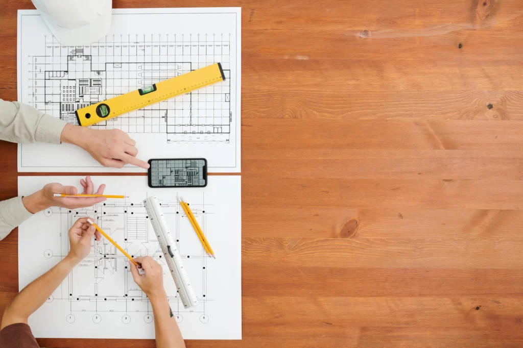 engineers preparing kitchen measurement plans with tools, drawings, and digital sketches