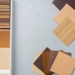 Selection of warm wood veneer samples in light, medium, and dark earthy tones for modern cabinet finishes.